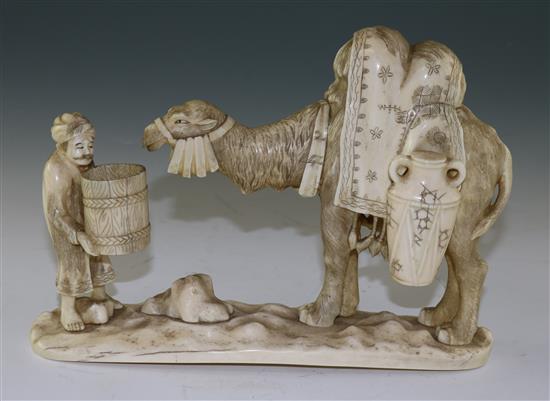 A Japanese sectional walrus ivory okimono of a Bactrian camel and a man, early 20th century, length 26cm